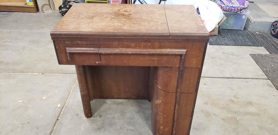 A wooden sewing machine desk in Art Deco styling