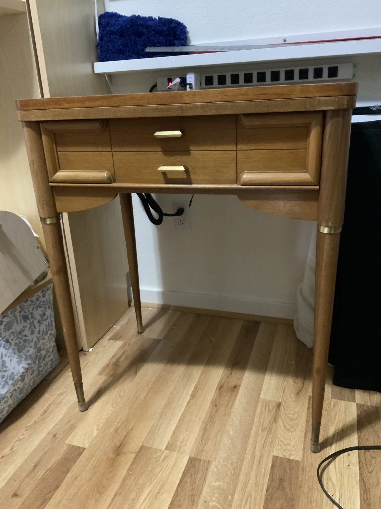 A mid-century modern table on a wood floor.