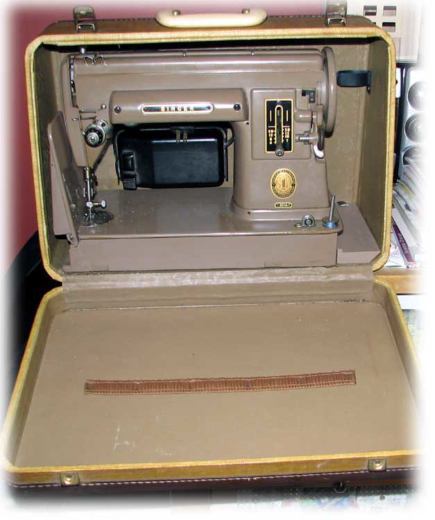 A tan sewing machine in a case
