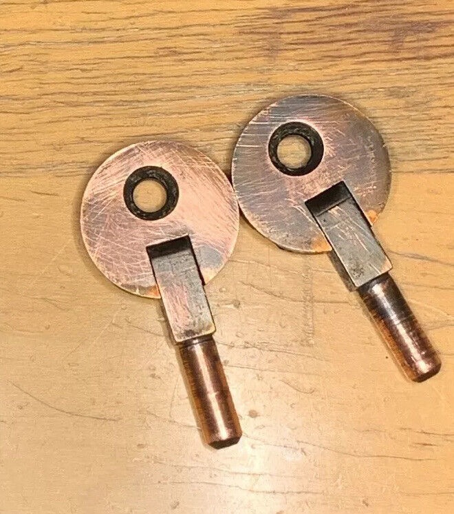 a pair of copper finished, round brass hinges