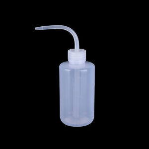 A translucent white plastic lab wash bottle on a black background